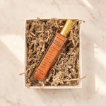 Lip balm in a decorative box with shredded paper on a marble surface