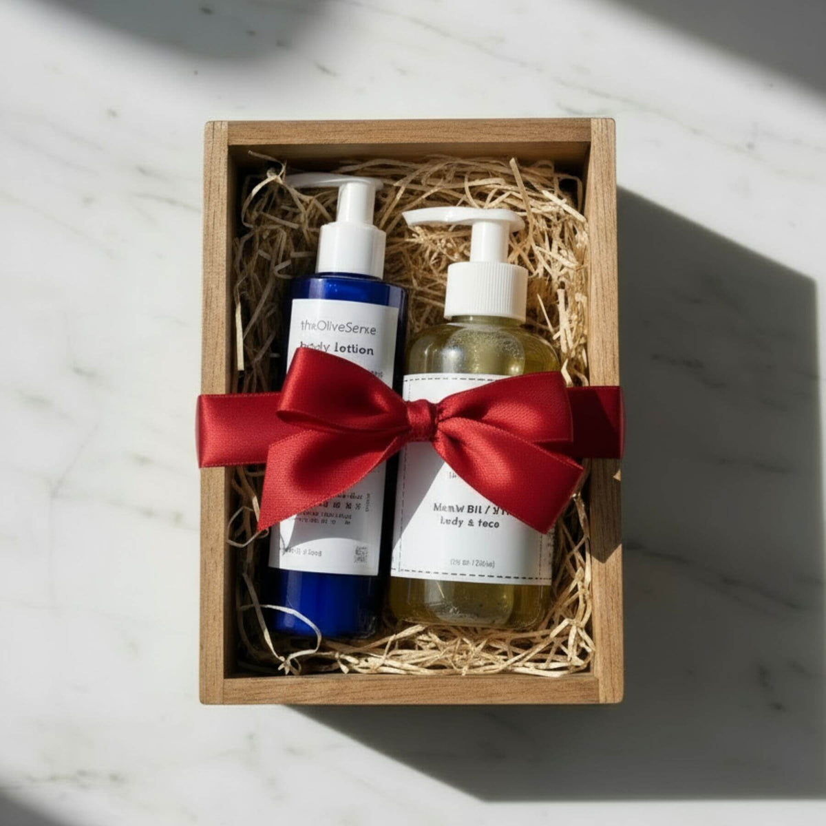 Two bottles with a red ribbon in a wooden box on a light surface