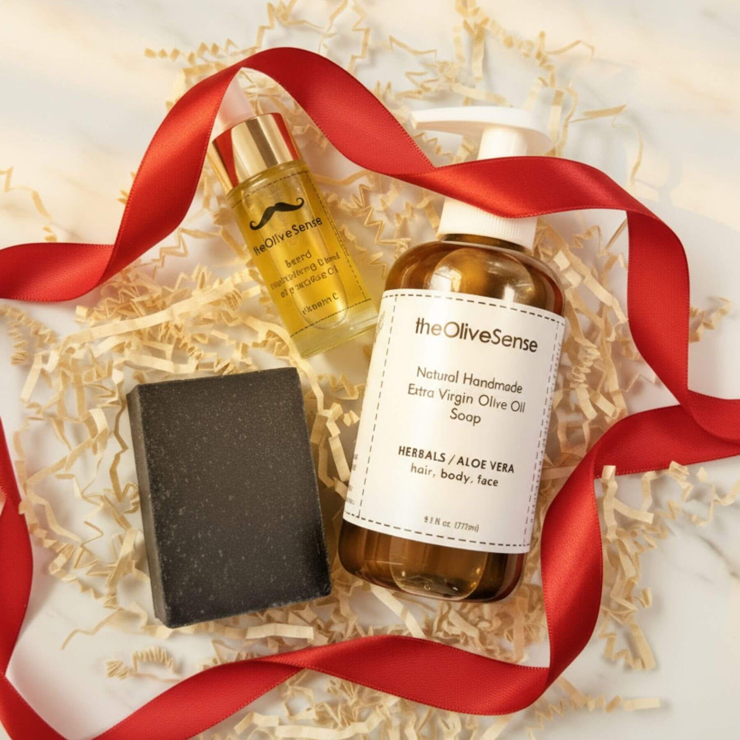 TheOlivesense products including a bottle, soap bar, and oil on a decorative background with a red ribbon.