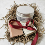 Body cream and soap with a red ribbon on crinkled paper