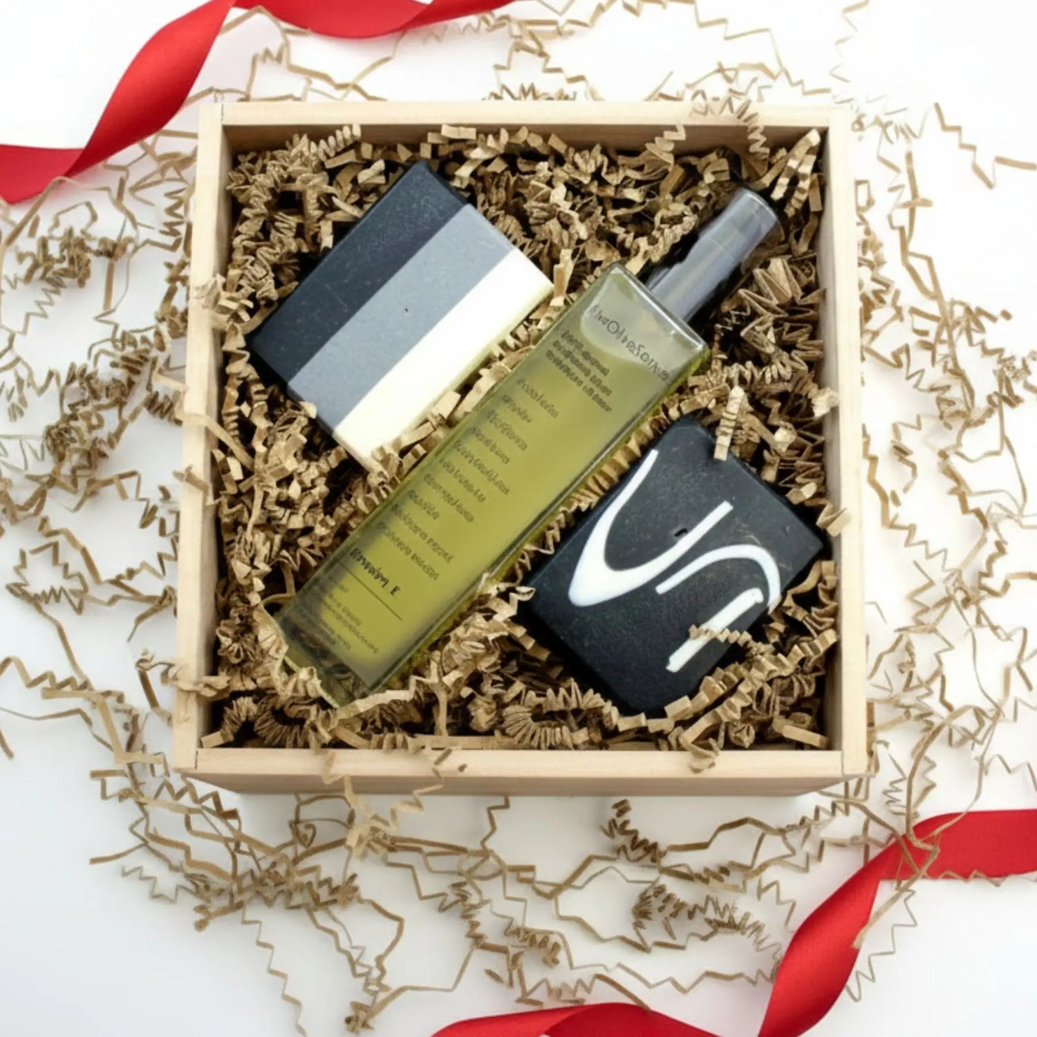 Three skincare products in a wooden box with decorative paper and ribbons.