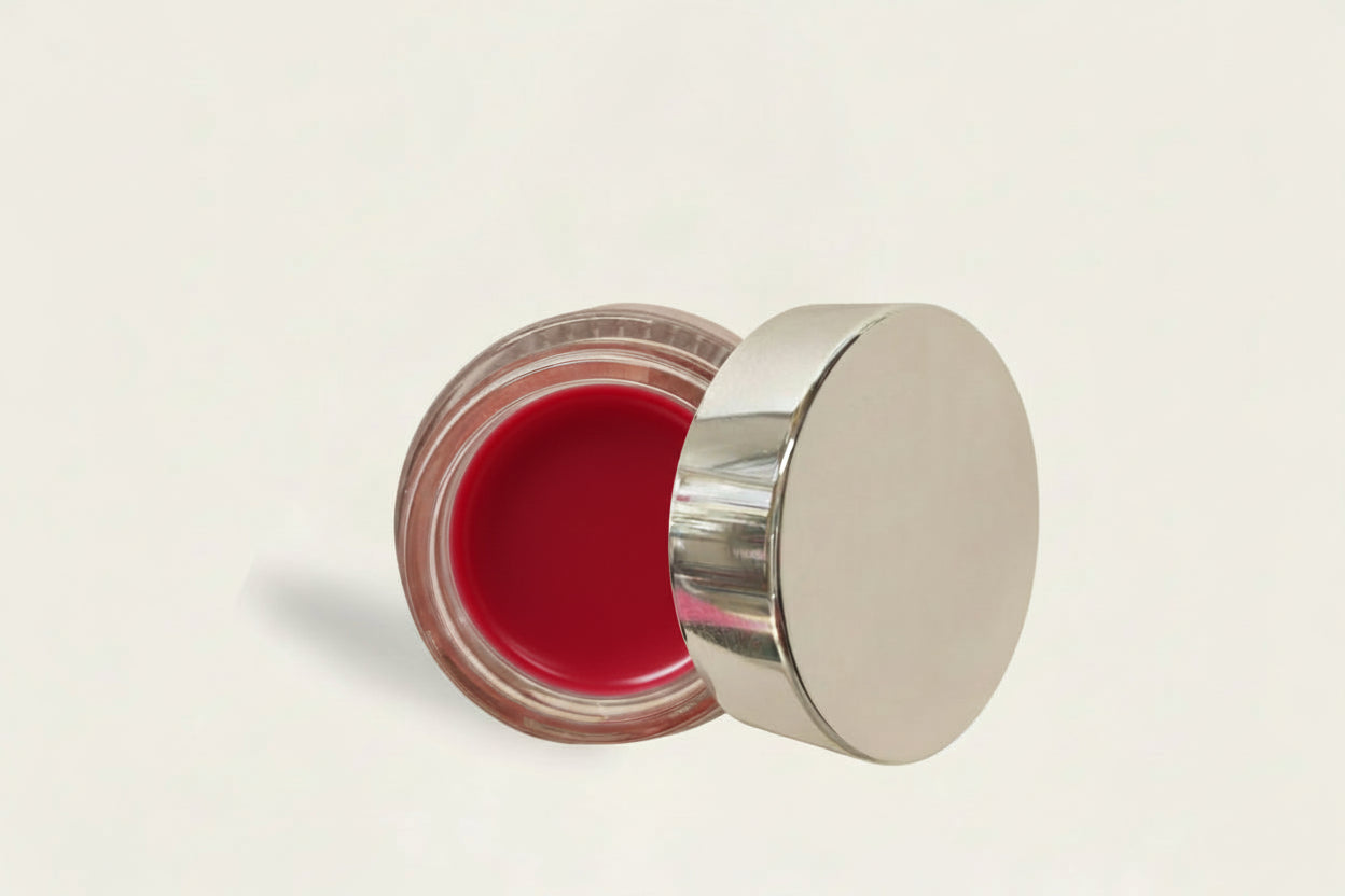 Open cosmetic jar with a metallic lid on a light background