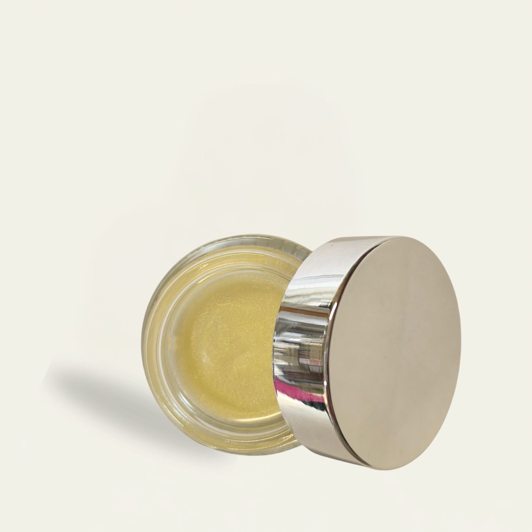 Small glass jar with a metal lid on a light background