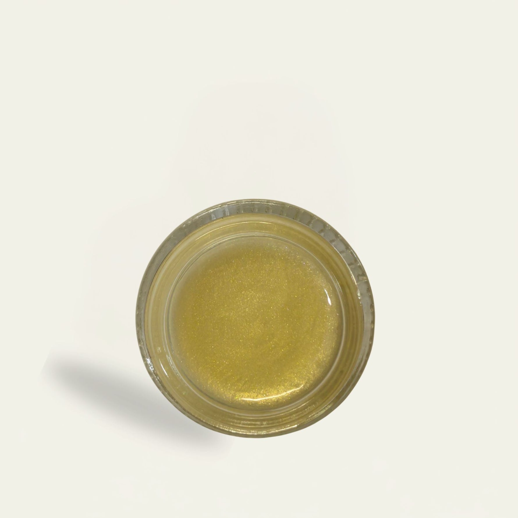 Small round container with a metallic rim on a light gray background