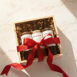 Three bottles of BeOliveSense product in a wooden box with a red ribbon on a light background