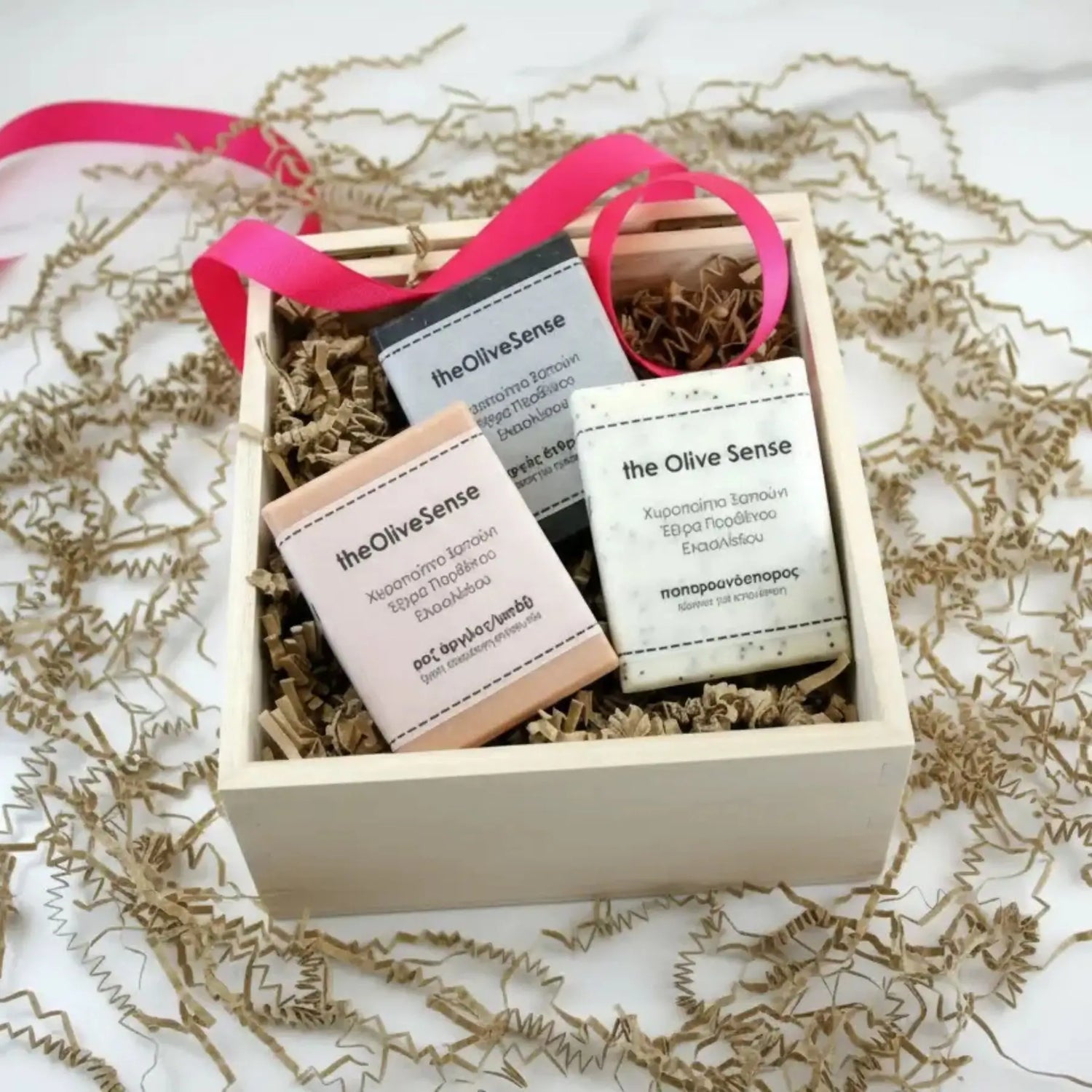 Gift set with 'the Olive Sense' products in a wooden box on a white background
