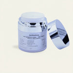 Jar of anti-aging face cream with a silver lid on a beige background