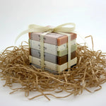 Stack of small wrapped packages tied with a ribbon on a bed of straw.
