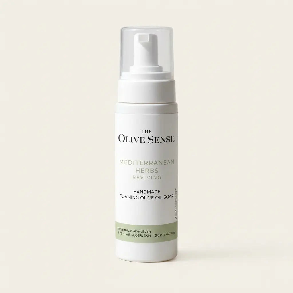 The Olive Sense Mediterranean Herbs Reviving Handmade Foaming Olive Oil Soap in a white pump bottle with a clear cap, set against a solid cream background.