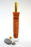 A bottle of OliveSense body moisturizing blend with a gold cap, displaying the product name and ingredients such as olive oil and vitamin E.