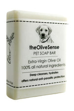 A white bar of pet soap with a label featuring a dog and the text 'The OliveSense Pet Soap Bar, extra virgin olive oil, 100% all natural ingredients, deep cleanses, hydrates, offers natural anti-parasitic protection'.